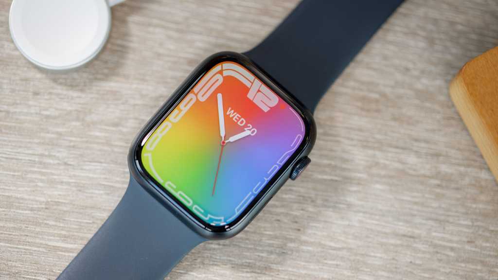 Apple Watch Series 7 with rainbow watchface on a desk