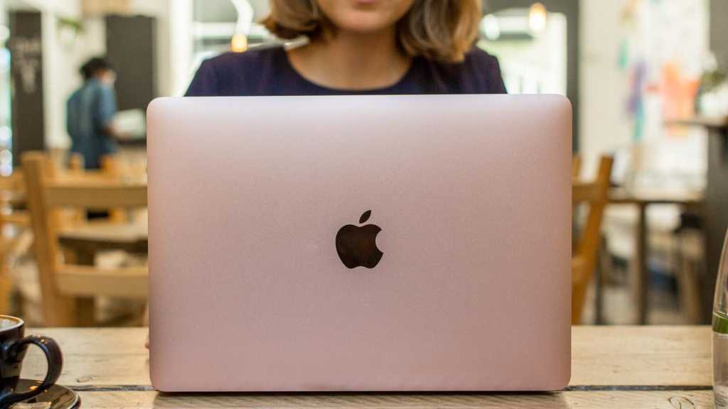 Mujer usando un MacBook rosa
